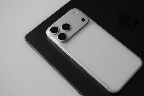 White cased phone with three cameras on a dark background