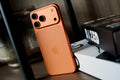 Orange cased phone with a triple camera cutout